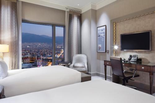 a hotel room with a bed and a desk and a window at Hilton Bursa Convention Center & Spa in Bursa