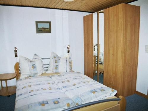a bedroom with a bed with white sheets and pillows at Strandfleh Modern retreat in Wangerooge