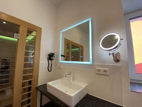 La salle de bains est pourvue d'un lavabo blanc et d'un miroir. dans l'établissement Attractive apartment in Olbersdorf, à Olbersdorf