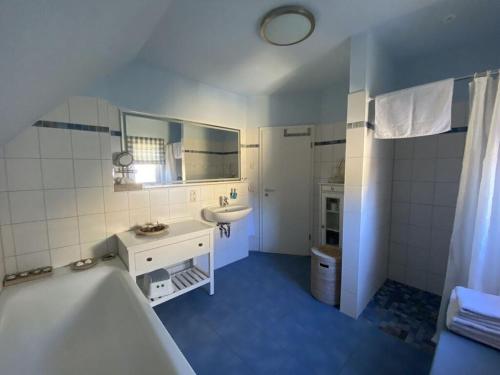 a bathroom with a tub and a sink and a bath tub at The Golfer's Blue in Unter Göhren