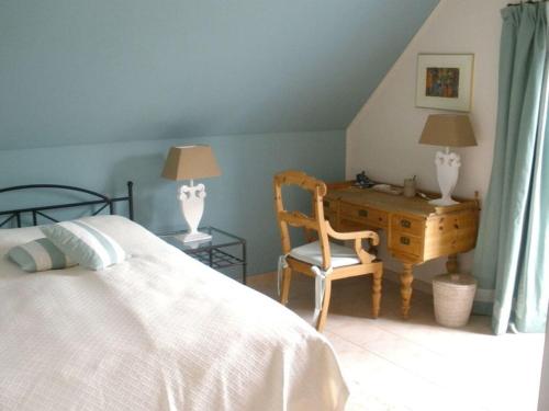 a bedroom with a bed and a desk and a chair at The Golfer's Blue in Unter Göhren