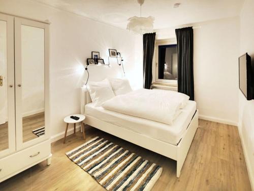 una camera bianca con un letto e una finestra di The parents' house Modern retreat a Clausthal-Zellerfeld
