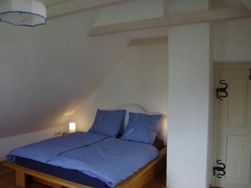 1 cama con almohadas azules en una habitación en Cozy Cottage Modern Retreat en Zankenhausen