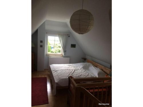 a small bedroom with a bed and a window at Red-throated diver Modern retreat in Putgarten