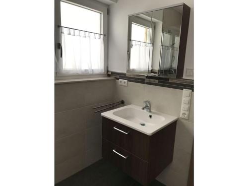 een badkamer met een wastafel en een spiegel bij Holiday home Baier in Philippsreut