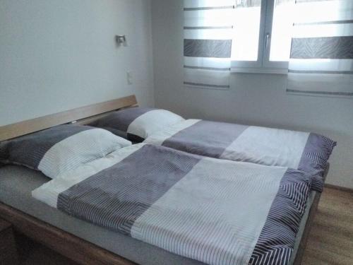 een bed met twee kussens in een slaapkamer bij Holiday home Baier in Philippsreut