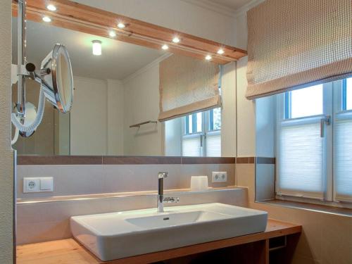 a bathroom with a white sink and a mirror at Castle view Modern retreat in Oberhof