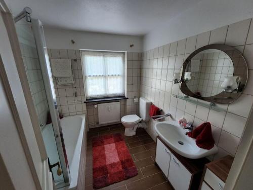ein Badezimmer mit Waschbecken, Toilette und Spiegel in der Unterkunft Waldhaus Sonnenberg Apartment 4 in Drachselsried