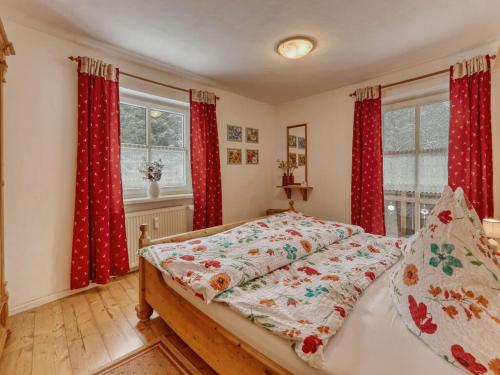 a bedroom with a bed with red curtains at Waldhaus Sonnenberg Apartment 4 in Drachselsried