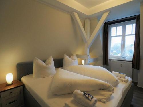 - une chambre avec 2 lits avec des oreillers blancs et une fenêtre dans l'établissement Villa Balticum Modern retreat, à Zingst