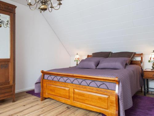 sypialnia z drewnianym łóżkiem z fioletową pościelą w obiekcie Elbwiesenhaus Modern retreat 