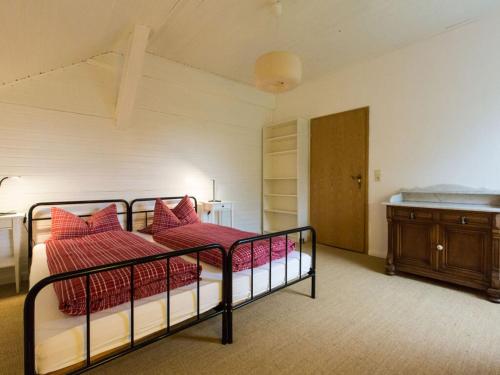 een slaapkamer met een bed met rode kussens bij in the estate worker's house 