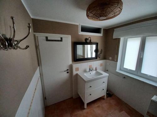 La salle de bains est pourvue d'un lavabo, d'un miroir et d'une fenêtre. dans l'établissement Time out Modern retreat, à Chieming