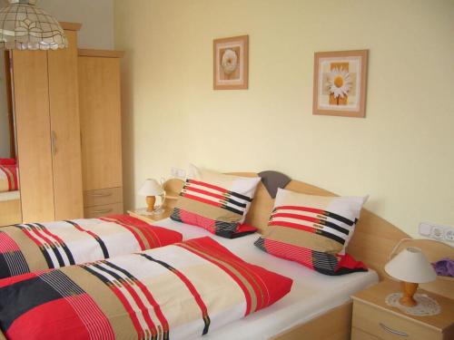 1 dormitorio con 2 camas, mantas y almohadas a rayas en Haus Nett Modern retreat, en Stiefenhofen