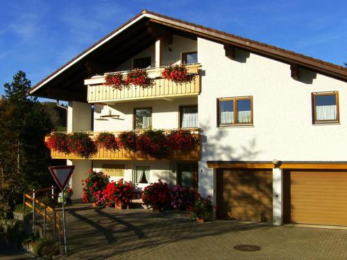 ein weißes Haus mit Blumenkästen an der Seite in der Unterkunft Haus Nett Modern retreat in Stiefenhofen