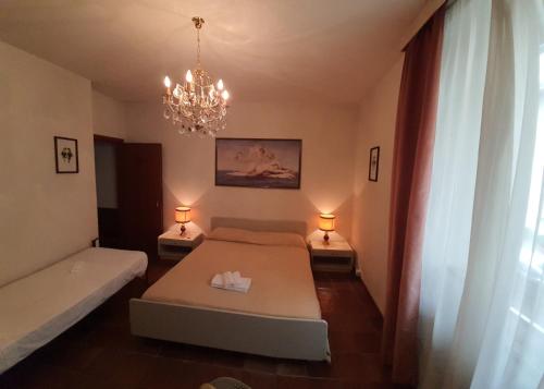 ein Schlafzimmer mit einem Bett, zwei Lampen und einem Kronleuchter in der Unterkunft La Grotta di San Michele in Montevettolini