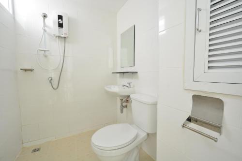 a white bathroom with a toilet and a sink at 42 Place in Bangkok