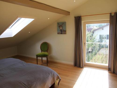 a bedroom with a bed and a window and a chair at Villa Carefree Suite in Grassau