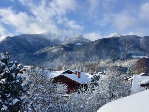 a town covered in snow with mountains in the background at Villa Carefree Suite in Grassau