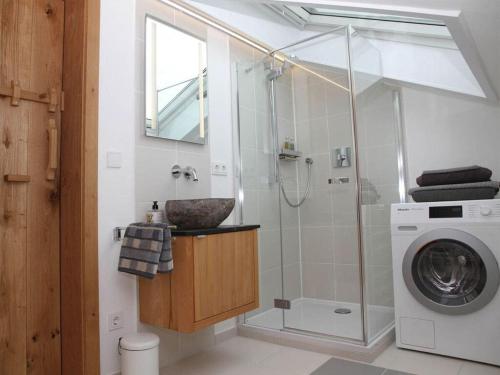 a bathroom with a shower and a washing machine at Villa Carefree Suite in Grassau