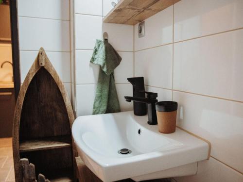 a bathroom with a white sink and a mirror at Pura Vida - holiday apartment in Fischen