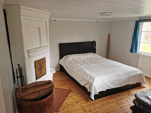 um quarto com uma cama e piso em madeira em Torpet em Sollebrunn