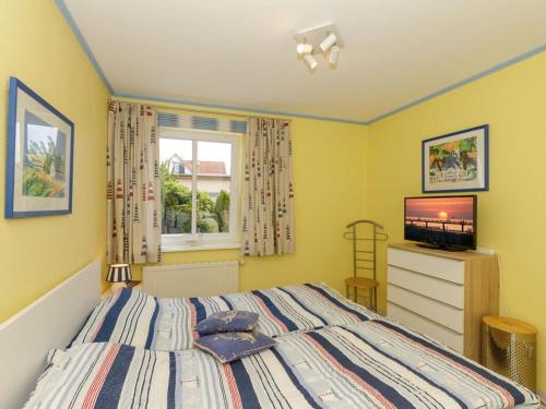 een slaapkamer met een bed en een televisie. bij 2 Am Stadtwald Modern retreat in Kühlungsborn