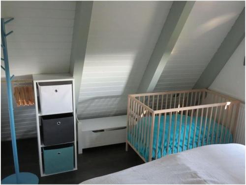 a bedroom with a crib and a white ceiling at Sunshine Modern Retreat in Ronshausen