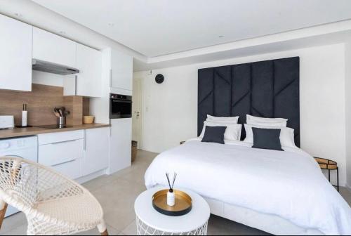 une chambre blanche avec un grand lit et une table dans l'établissement B045-Studio croisette AC close Congress center SEA, à Cannes