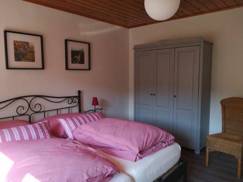 1 dormitorio con 1 cama con almohadas rosas en Holiday apartment at the linden tree, en Dernbach