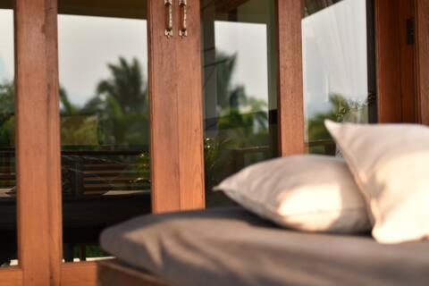 uma cama com duas almofadas brancas e uma janela em Wichouda Homestay em Chiang Dao