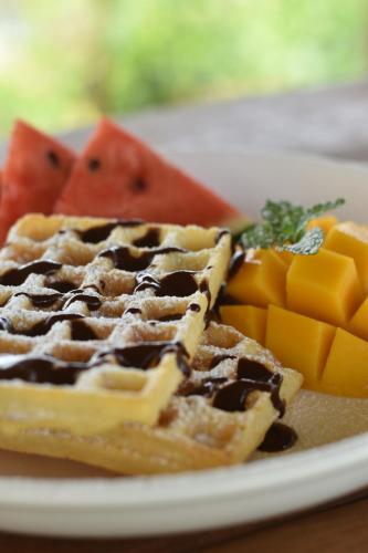 een bord wafels en fruit op een tafel bij Wichouda Homestay in Chiang Dao