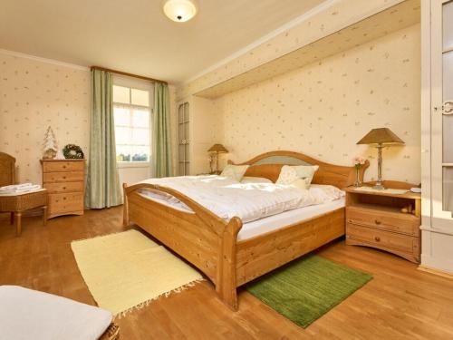 a bedroom with a large wooden bed with a green rug at Landhuis Appartement Feldberg uitzicht in Sankt Märgen