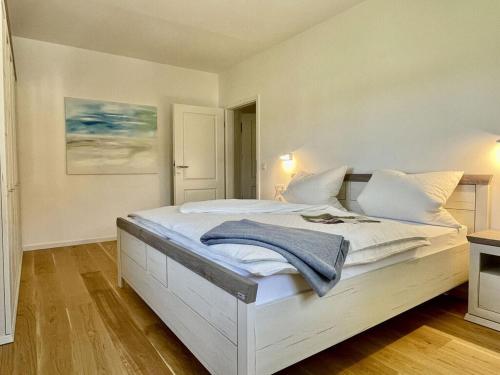 a bedroom with a white bed with a blue towel on it at Oberland Stadlberg in Miesbach