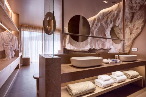 a bathroom with a sink and a mirror and towels at Ethereum Mykonos in Mýkonos City