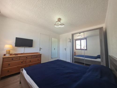 a bedroom with a blue bed and a television at Meijotel - 59 - Appt tres spacieux 6-7 pers in Les Deux Alpes