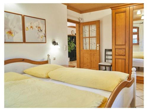 um quarto com 2 camas com lençóis amarelos em Holiday guesthouse Posthof em Waldmünchen