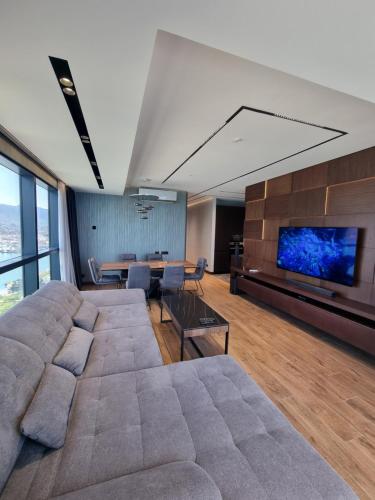 salon z dużą kanapą i telewizorem w obiekcie Premium apartment in Porta Batumi Tower w mieście Batumi