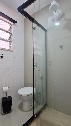 a bathroom with a toilet and a glass shower at Residencial do Centro in Niterói