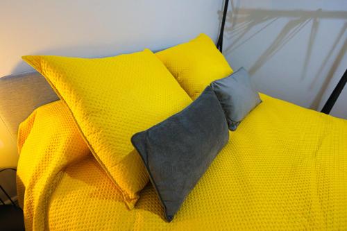 a yellow bed with yellow pillows on top of it at Gouveia Vintage House in Gouveia