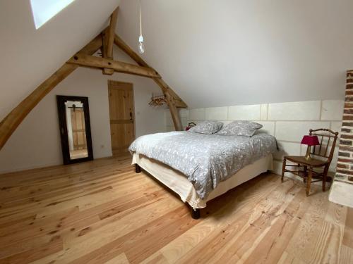 a bedroom with a bed and a wooden floor at Logement du Coteau entre Beauval et Amboise in Faverolles-sur-Cher