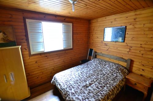 - une chambre avec un lit dans une cabane en bois dans l'établissement Hostel Cuesta, à Botucatu