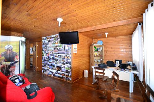 - un salon avec un canapé rouge et un bureau dans l'établissement Hostel Cuesta, à Botucatu