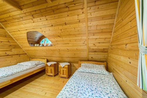 a room with two beds in a wooden cabin at Bacówka Polanki in Obidowa