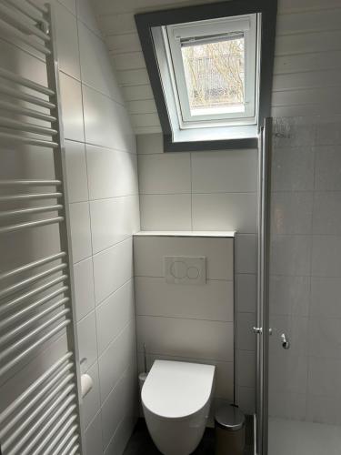 a small bathroom with a toilet and a window at Idylle Seepark - Haus mit Pool und Fasssauna in Kirchheim