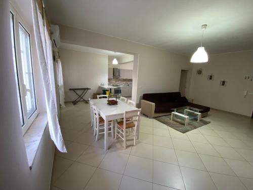 ein Wohnzimmer mit einem Tisch und einem Sofa in der Unterkunft Appartamento Casa vacanza fronte mare in Venetico