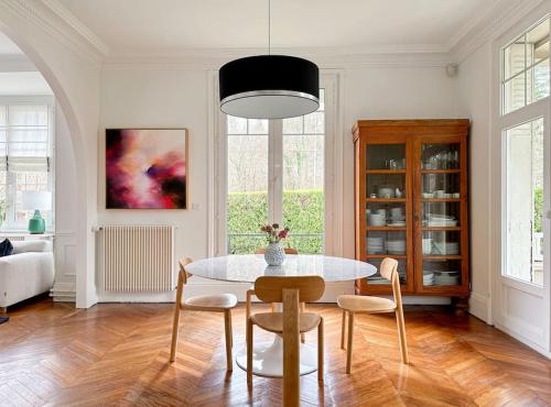 a dining room with a table and some chairs at La Feuilleraie - Maison de charme avec piscine in Compiègne