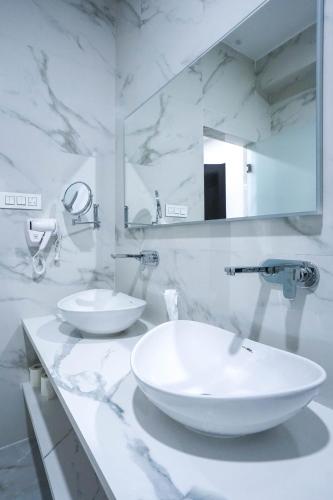 a white bathroom with a sink and a mirror at Dey Ngyam Boutique in Geylegphug
