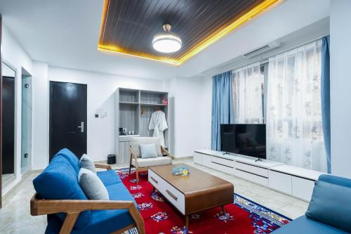 a living room with a blue couch and a tv at Dey Ngyam Boutique in Geylegphug