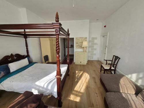 a bedroom with a canopy bed and a couch at Studio next to port, cliffs, with parking in Kent